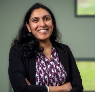 woman smiling at camera with arms crossed